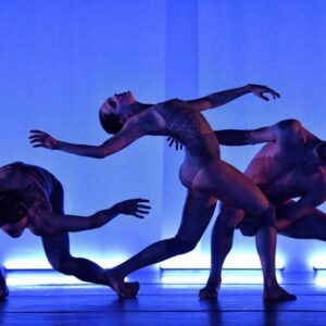 Three Ballet BC artists mid-performance in Relic silhouetted against a a blue background.